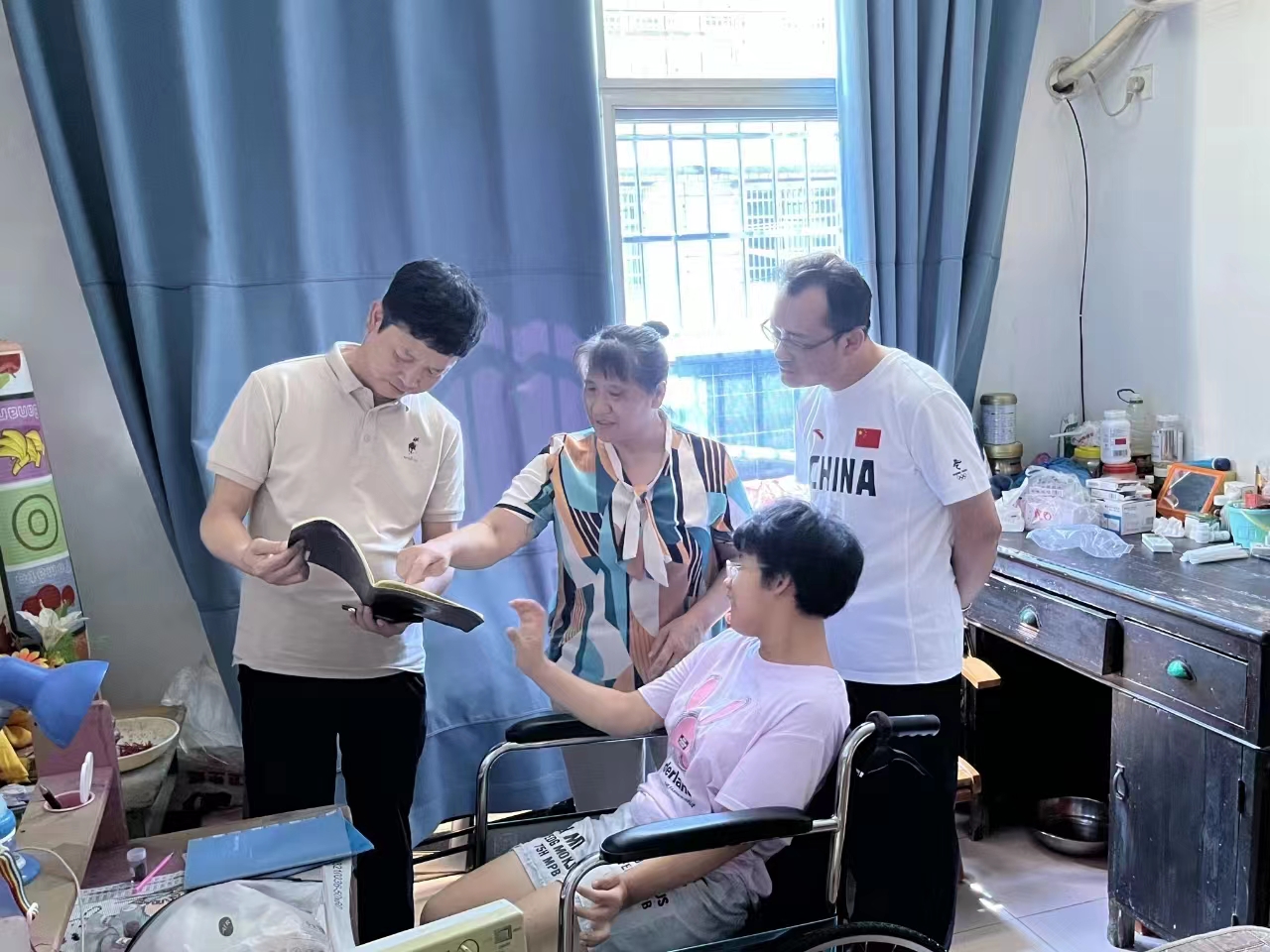 图为调研组一行看望冷水滩梅湾办事处脑瘫女孩曹春林