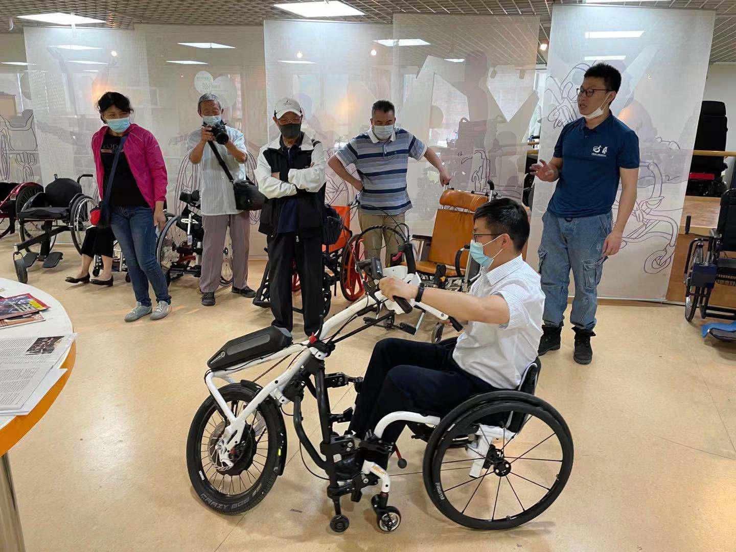 图为参观人员体验辅助器具