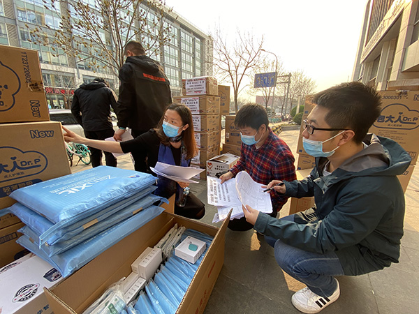 图为中国残疾人辅助器具中心工作人员正在清点待配送辅具产品及防疫物资