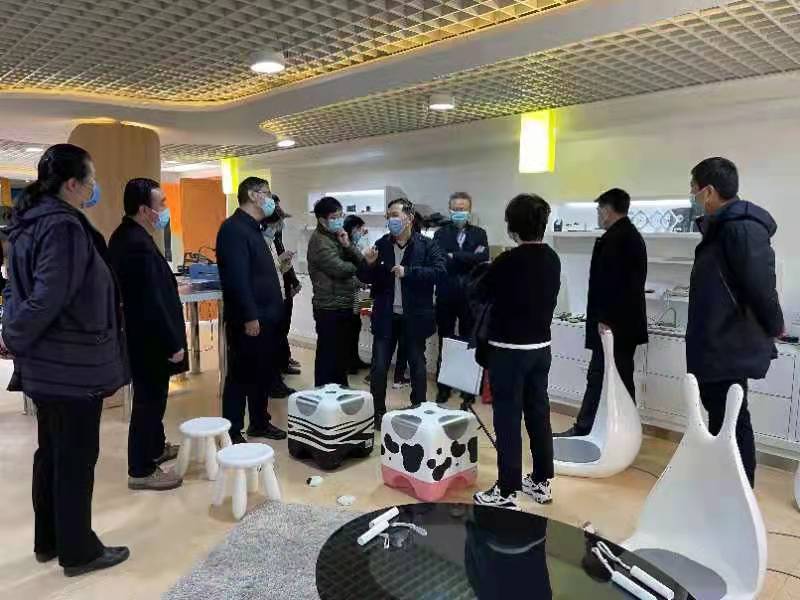 图为向来访人员介绍助听辅助器具