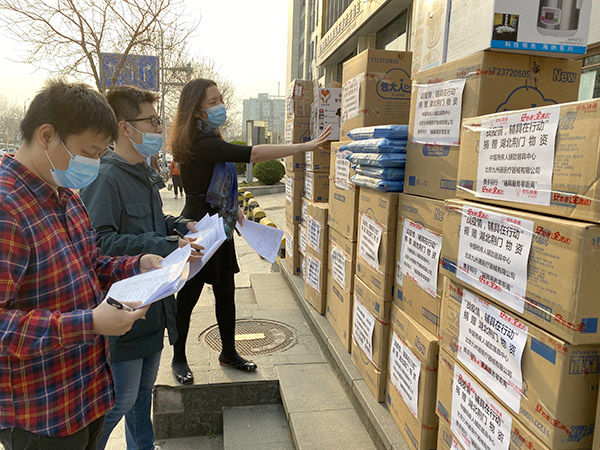 图为中国残疾人辅助器具中心工作人员正在清点待配送辅具产品及防疫物资